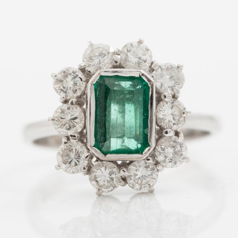 Ring 18K white gold set with a step-cut emerald and round brilliant-cut diamonds.