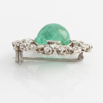 A platinum brooch with a cabochon-cut emerald.