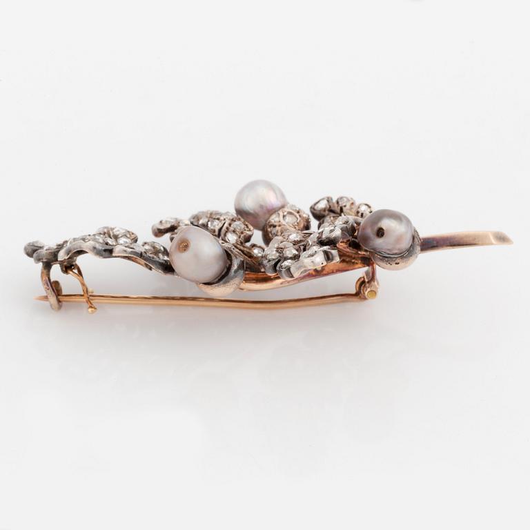 A silver and gold brooch set with pearls and rose-cut diamonds.