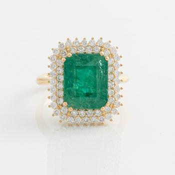 Ring with emerald-cut emerald and brilliant-cut diamonds.