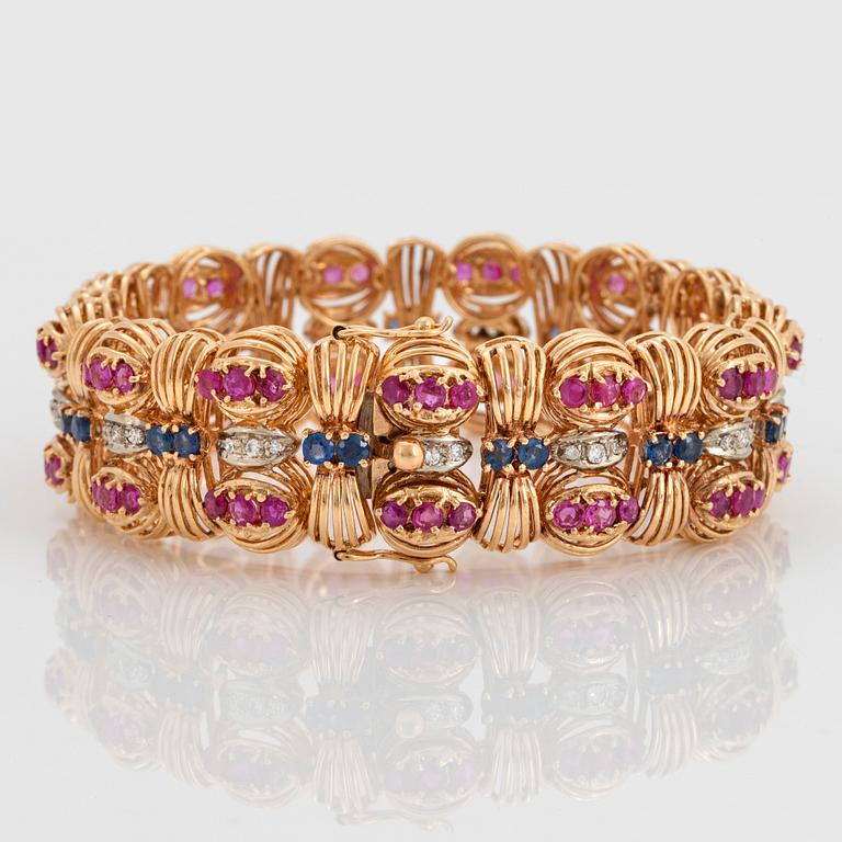 An 18K gold Bucherer bracelet set with blue and pink sapphires and round brilliant-cut diamonds.