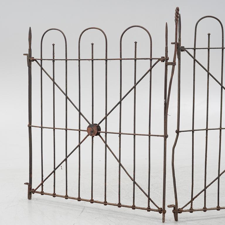 A pair of iron garden gates and a single gate from the early 20th century.