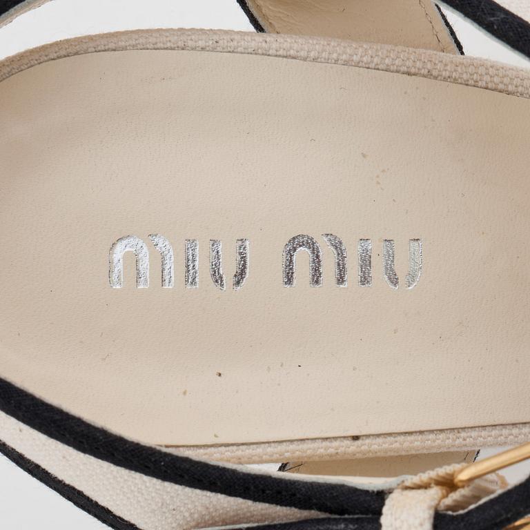 MIU MIU, a pair of creme white canvas sandals.