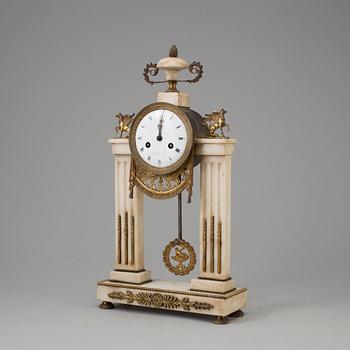 A FRENCH EMPIRE MARBLE AND BRASS MANTEL CLOCK, first half of the 19th century.