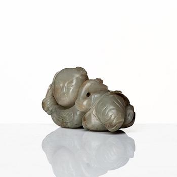 A neprite sculpture of a reclining boy with a duck, late Qing dynasty.