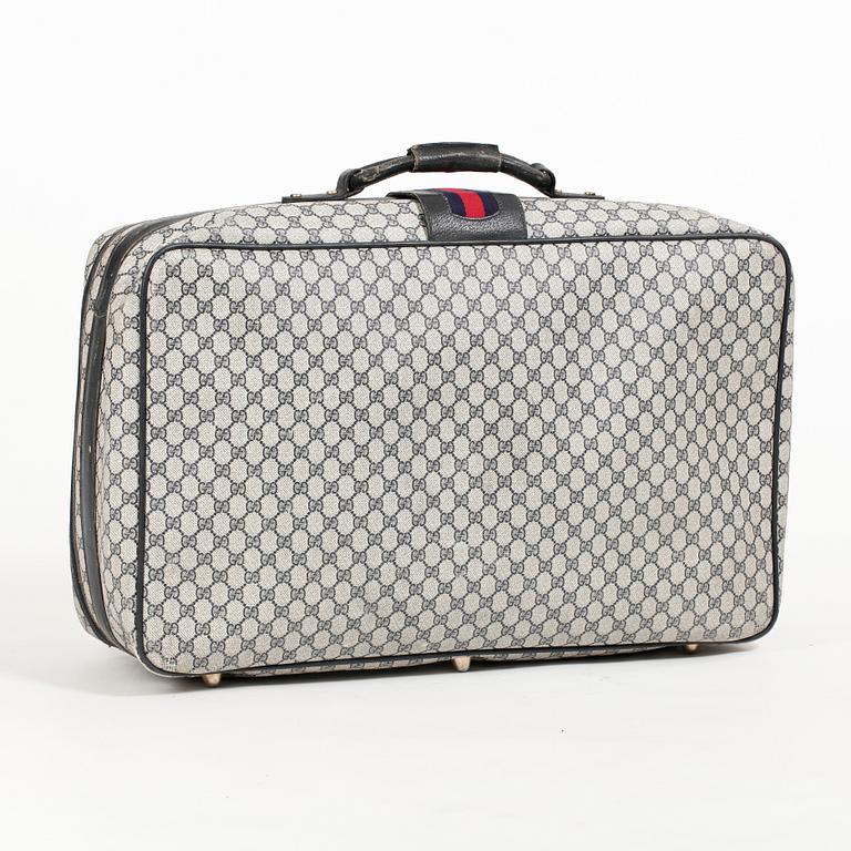 GUCCI, a blue monogram canvas suitcase.