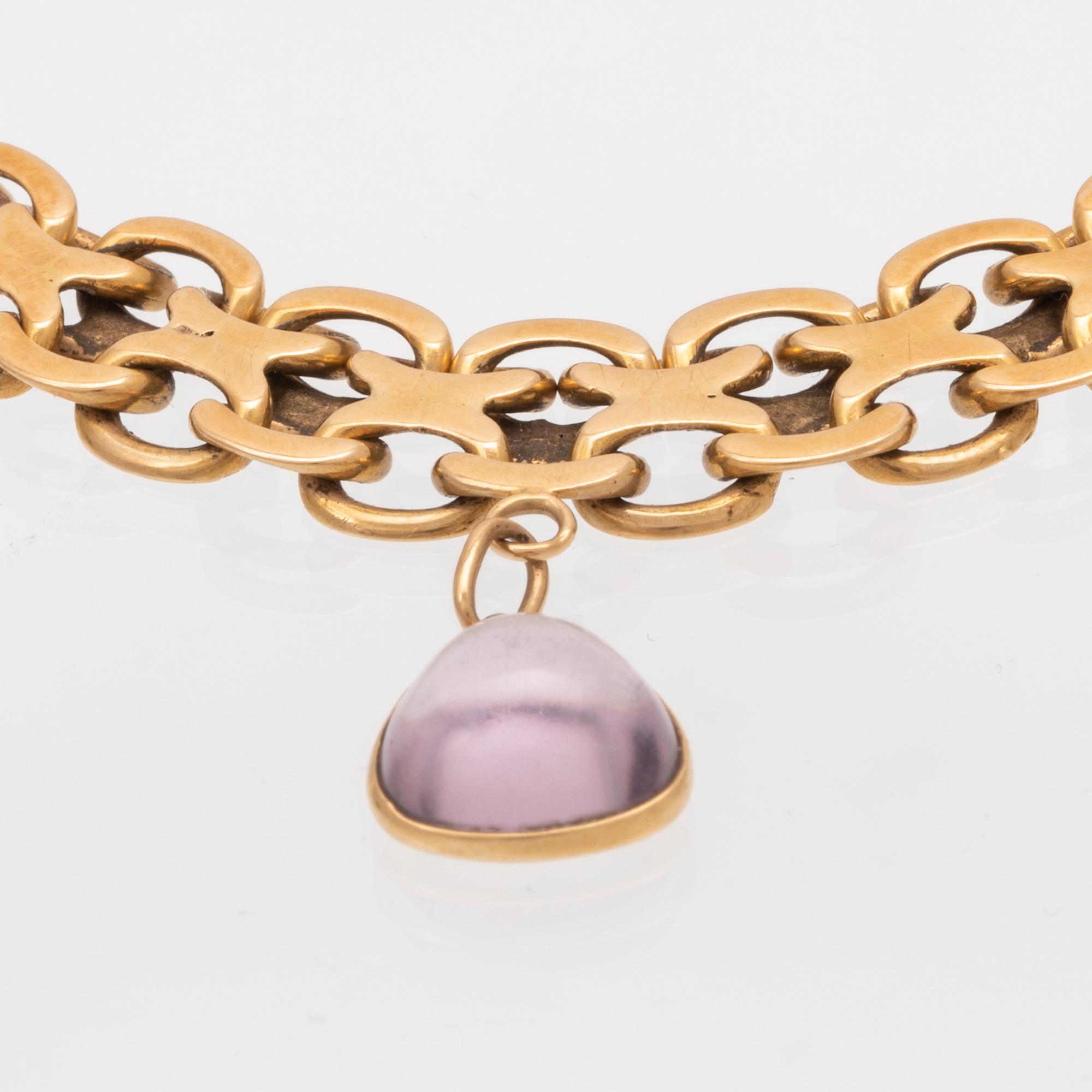 An 18K gold x-link bracelet with cabochon cut amethyst.