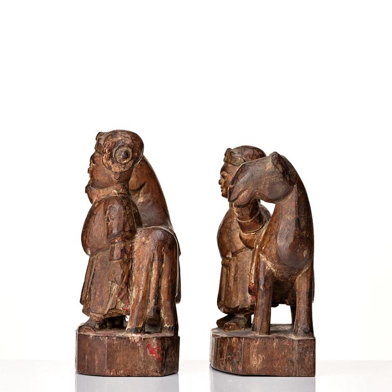 A pair of wooden sculptures of a man with a horse, Qing dynasty, circa 1900.