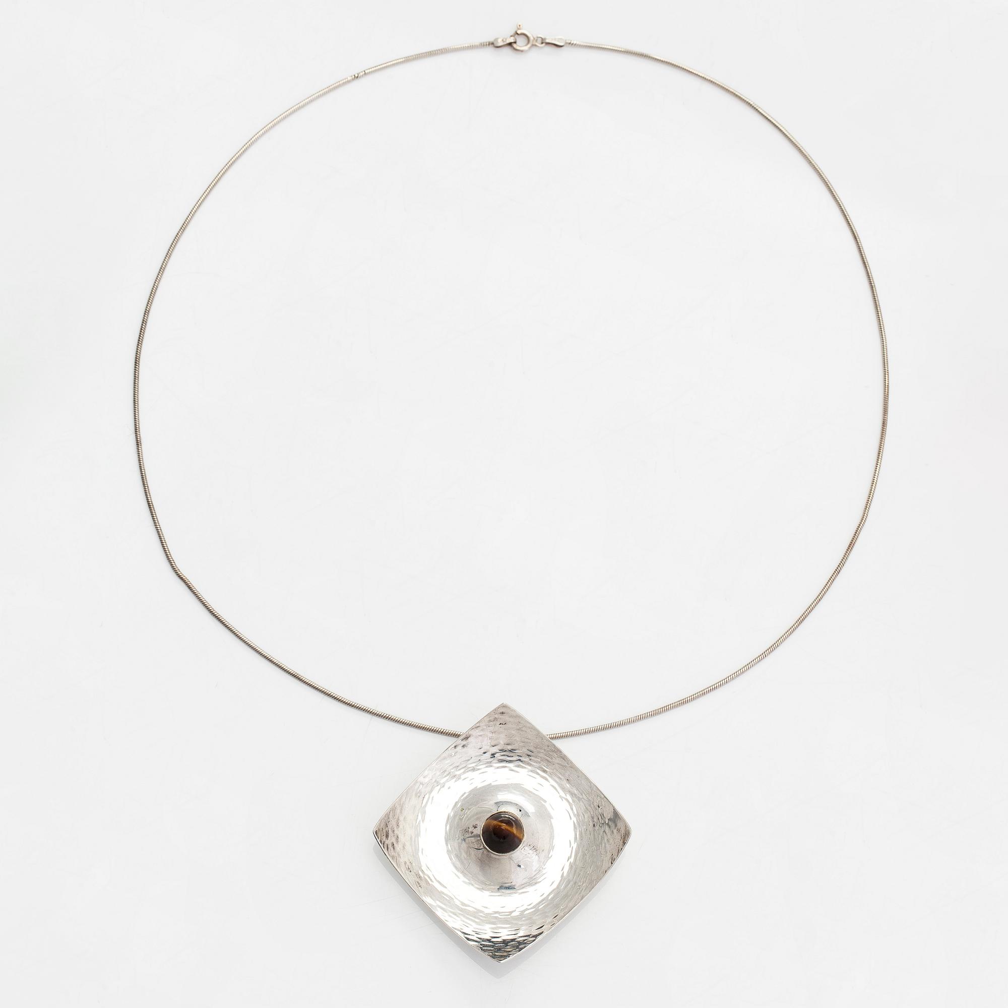 Elis Kauppi, a silver brooch/pendant, and tiger's eye. Kupittaan Kulta, Turku 1962.