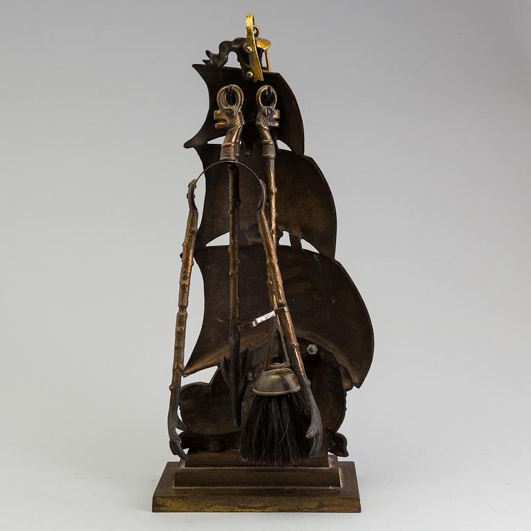 A set of three, early 20th century, bronze fire irons together with a stand, Nestor, England.