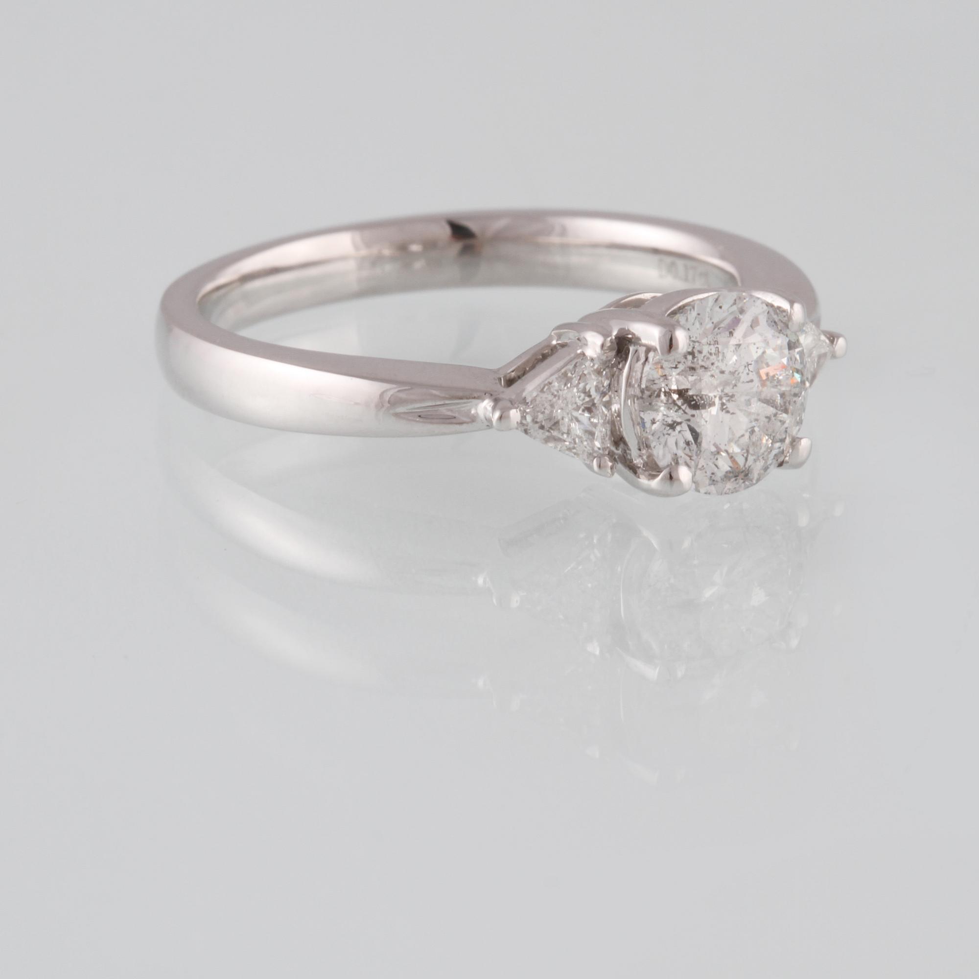 RING, 18K vitguld med briljantslipad diamant 1.03 ct samt 2 triangelslipade diamanter 0.17 ct. Vikt 4,4 gram.
