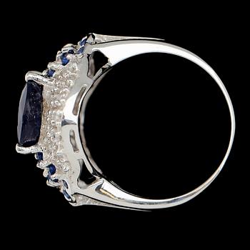 RING, sterlingsilver, oval safir ca 5.90 ct, mindre blå safirer tot ca 0.52 ct, vita safirer tot ca 0.84 ct.