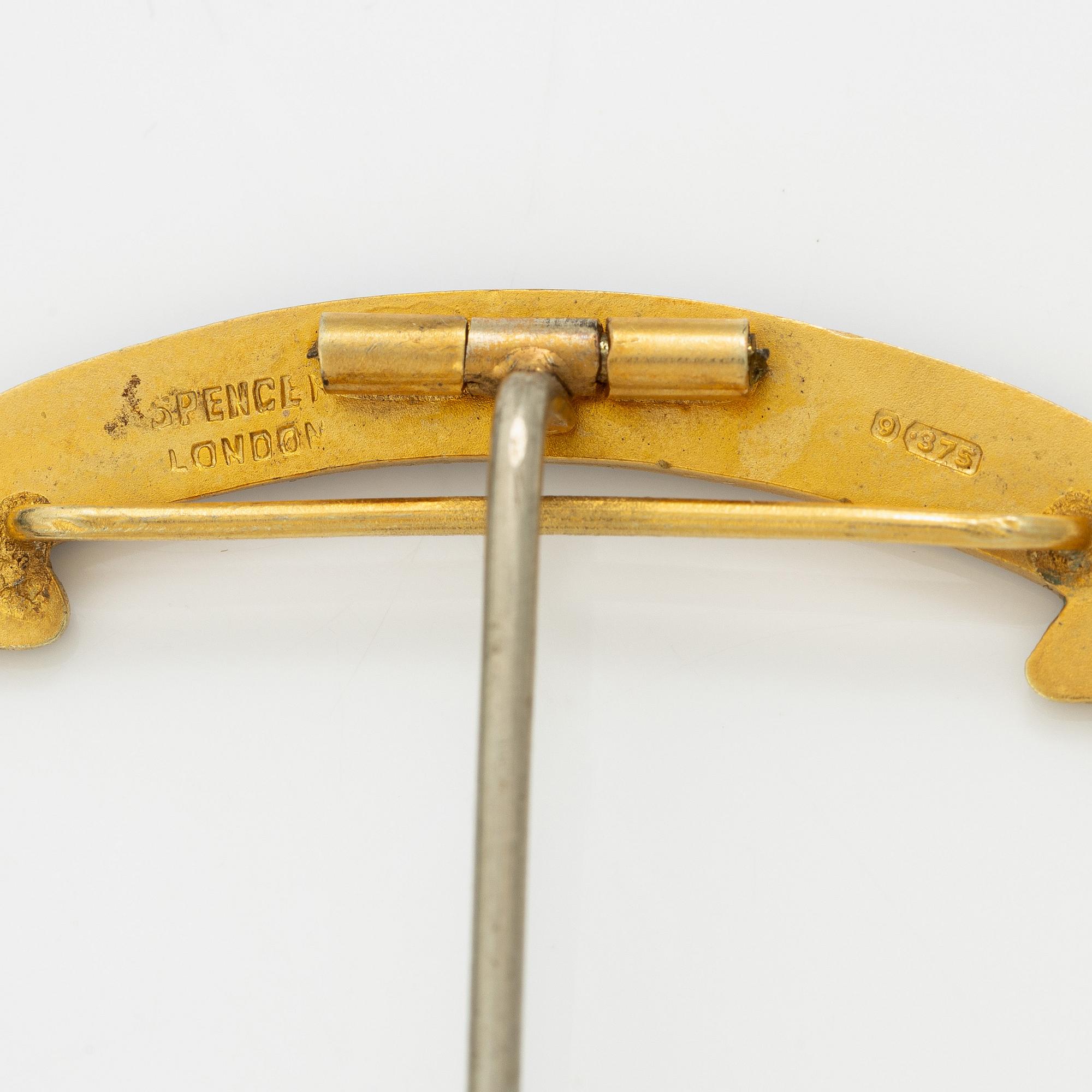 A jeton and pin, in gilded silver and 9 ct gold respectively.