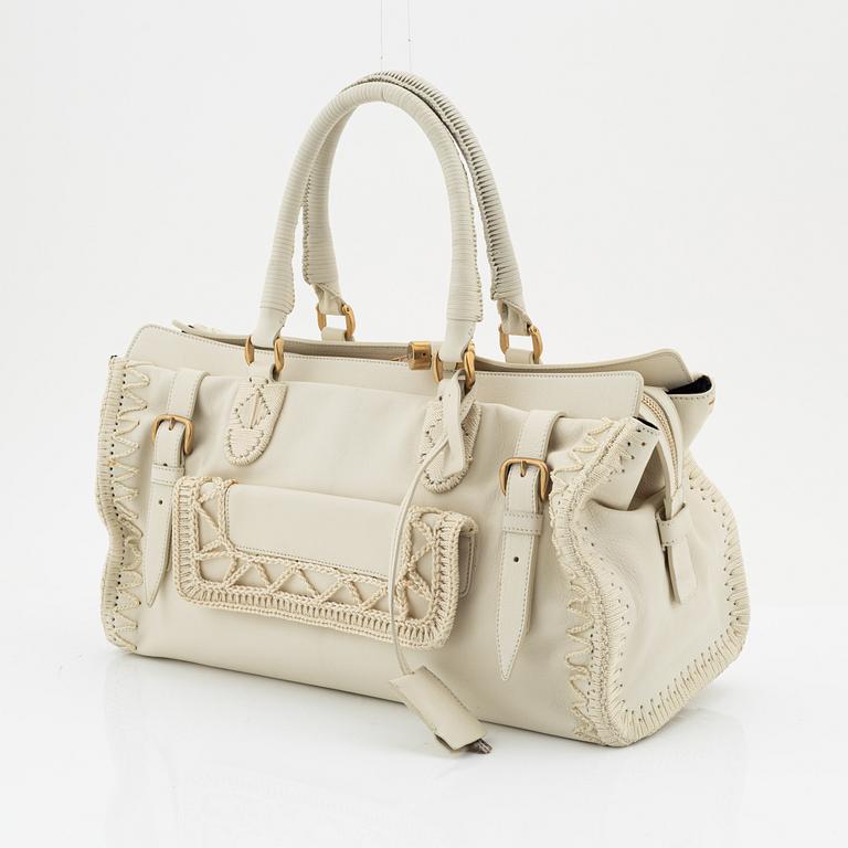 Yves Saint Laurent, a cream coloured goatskin bag with crocheted details.