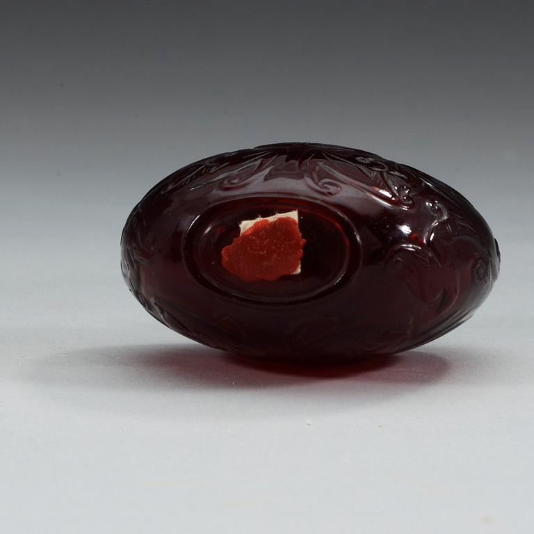 A large red sculptured peking glass snuff bottle with stopper, presumably around 1900.