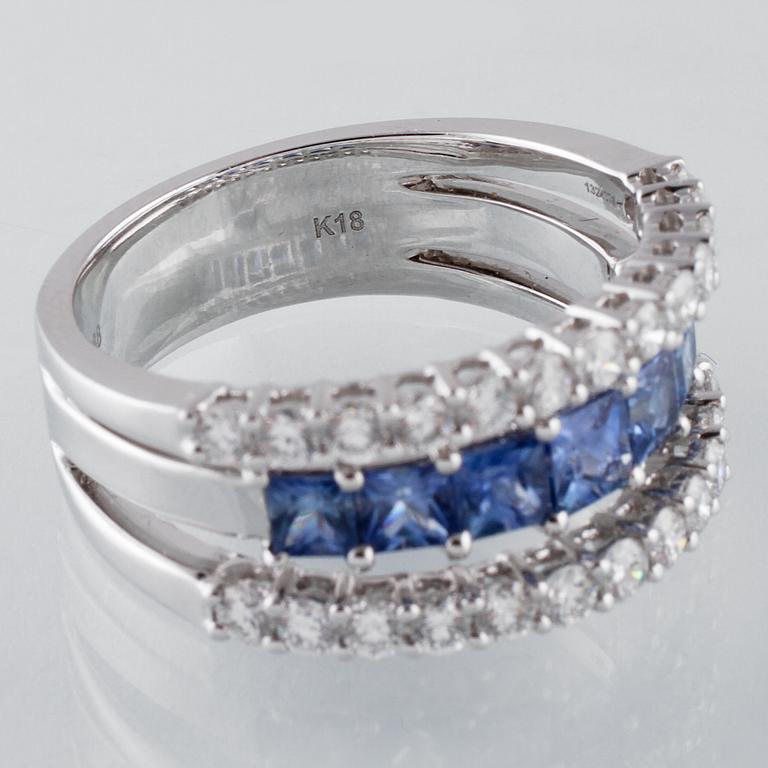 RING, 18K vitguld med 26 briljantslipade diamanter 0.88 ct samt 7 blå safirer 1.36 ct. Vikt 7,8 gram.