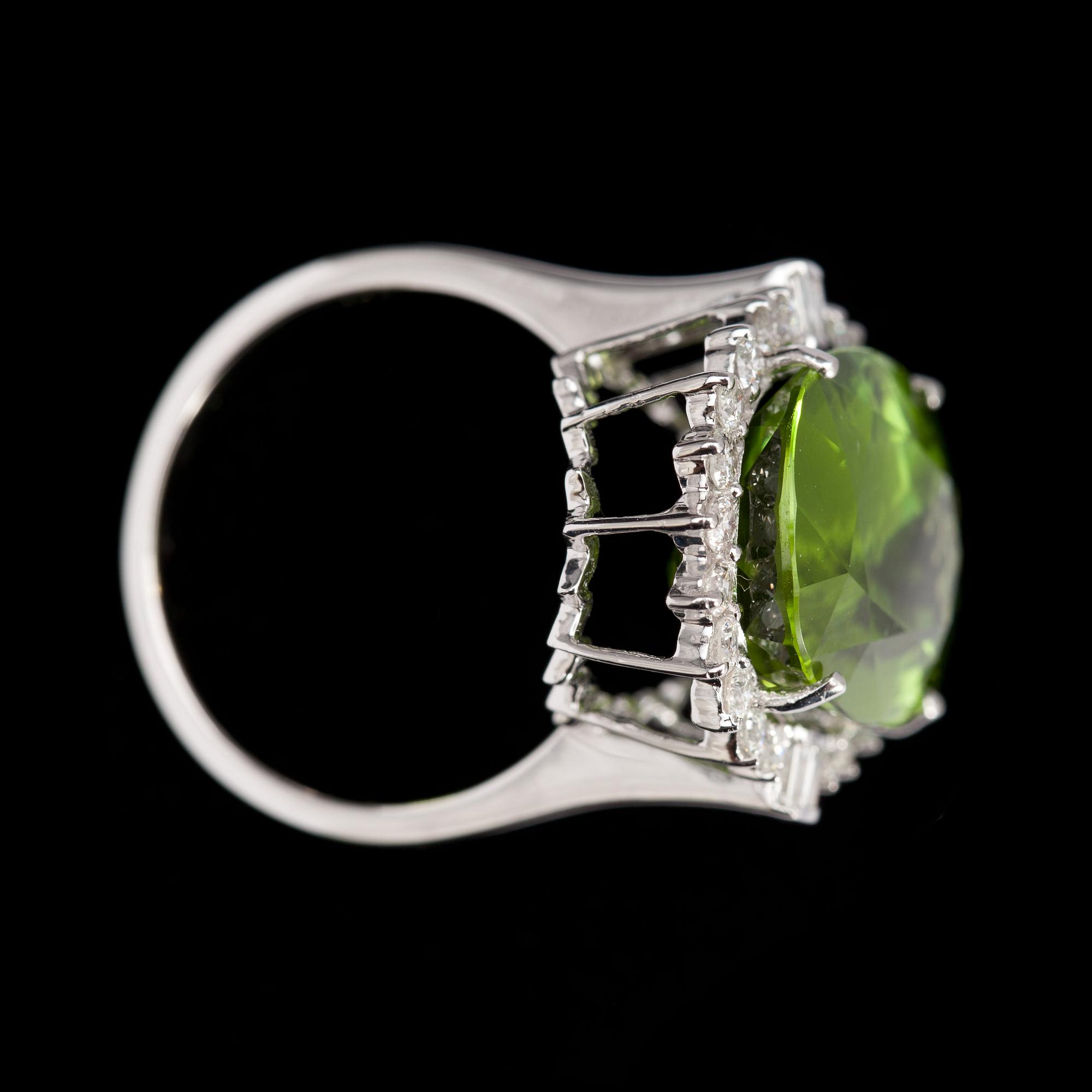 RING, fasettslipad peridot, 13.16 ct, samt briljantslipade diamanter, tot. 0.74 ct.