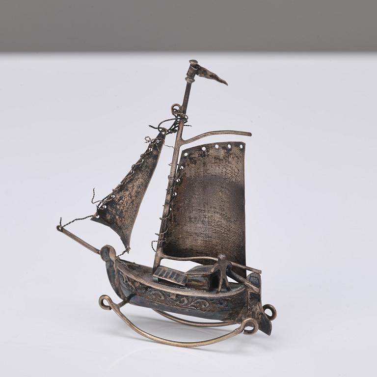 A table-bell, tray, ash-trays, snuff box, clip and a miniature-ship, silver plated and brass. 20th century.