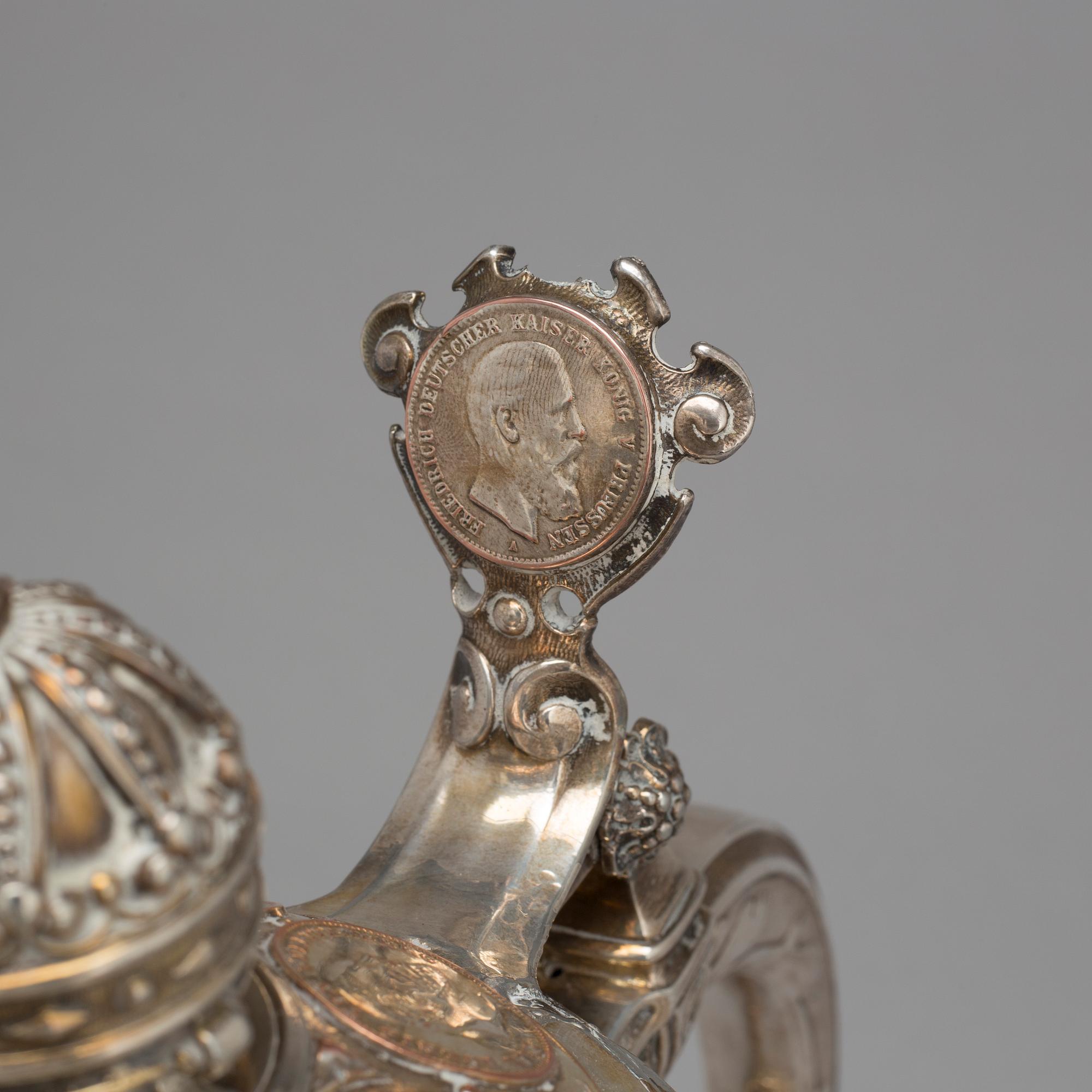 A late 19th century EPNS tankard with silver coins.