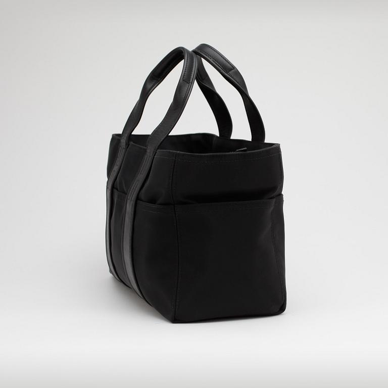 HERMÈS, a black nylon bag with leather details.