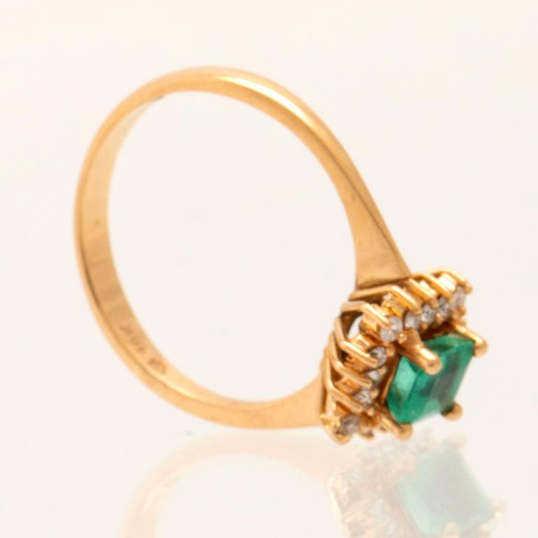 Ring in 18K gold with a step-cut emerald and round brilliant-cut diamonds.