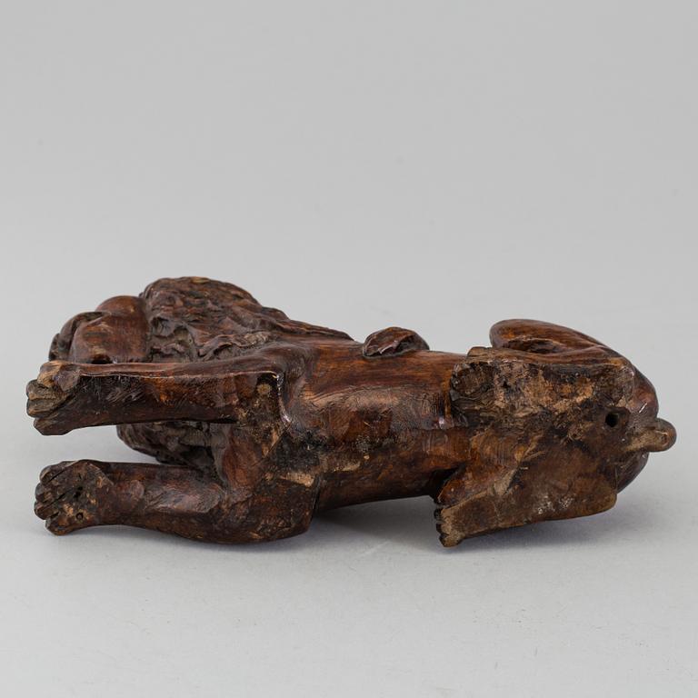 A 17TH CENTURY CARVED WOOD FIGURE OF A LION.