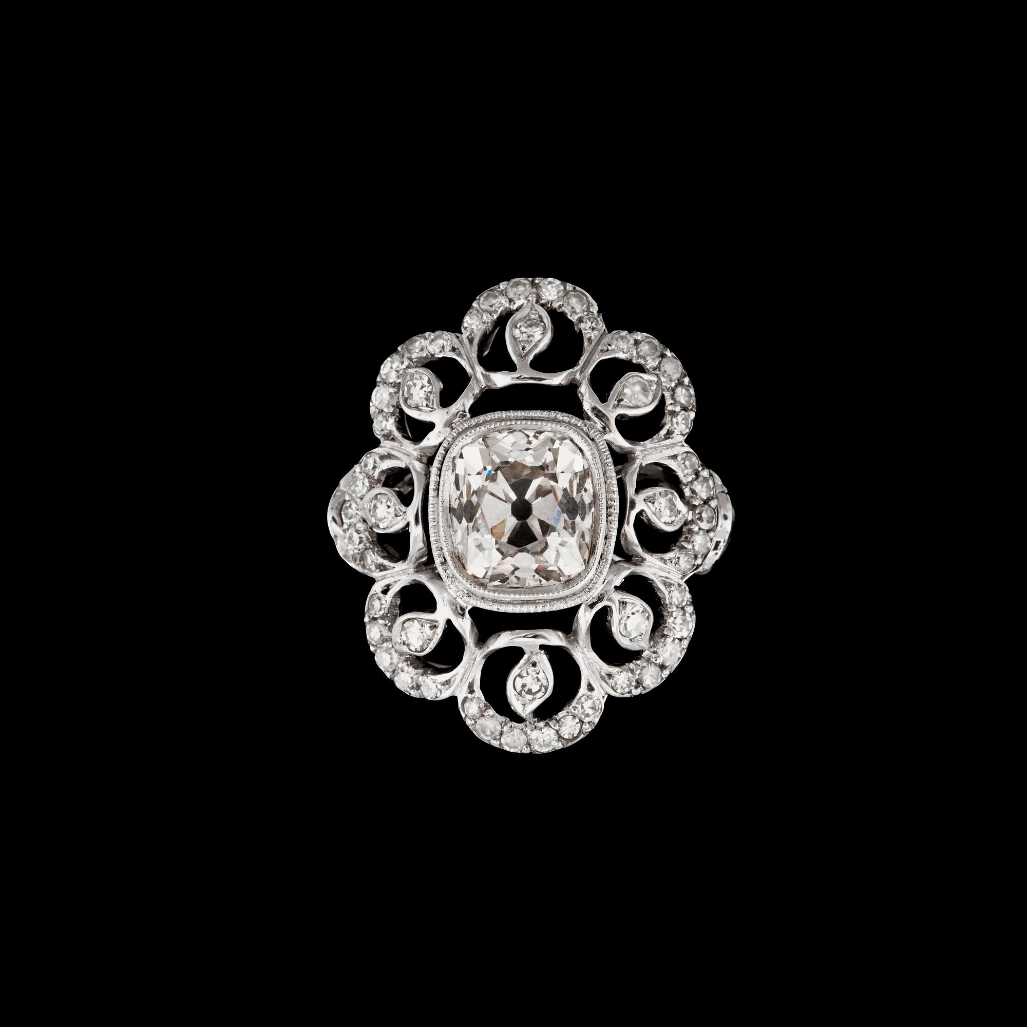 An old-cut diamond ring. Center stone circa 1.94 cts, surrounded by 70 smaller diamonds with different cuts.