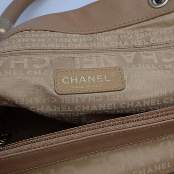 CHANEL, a beige leather handbag.