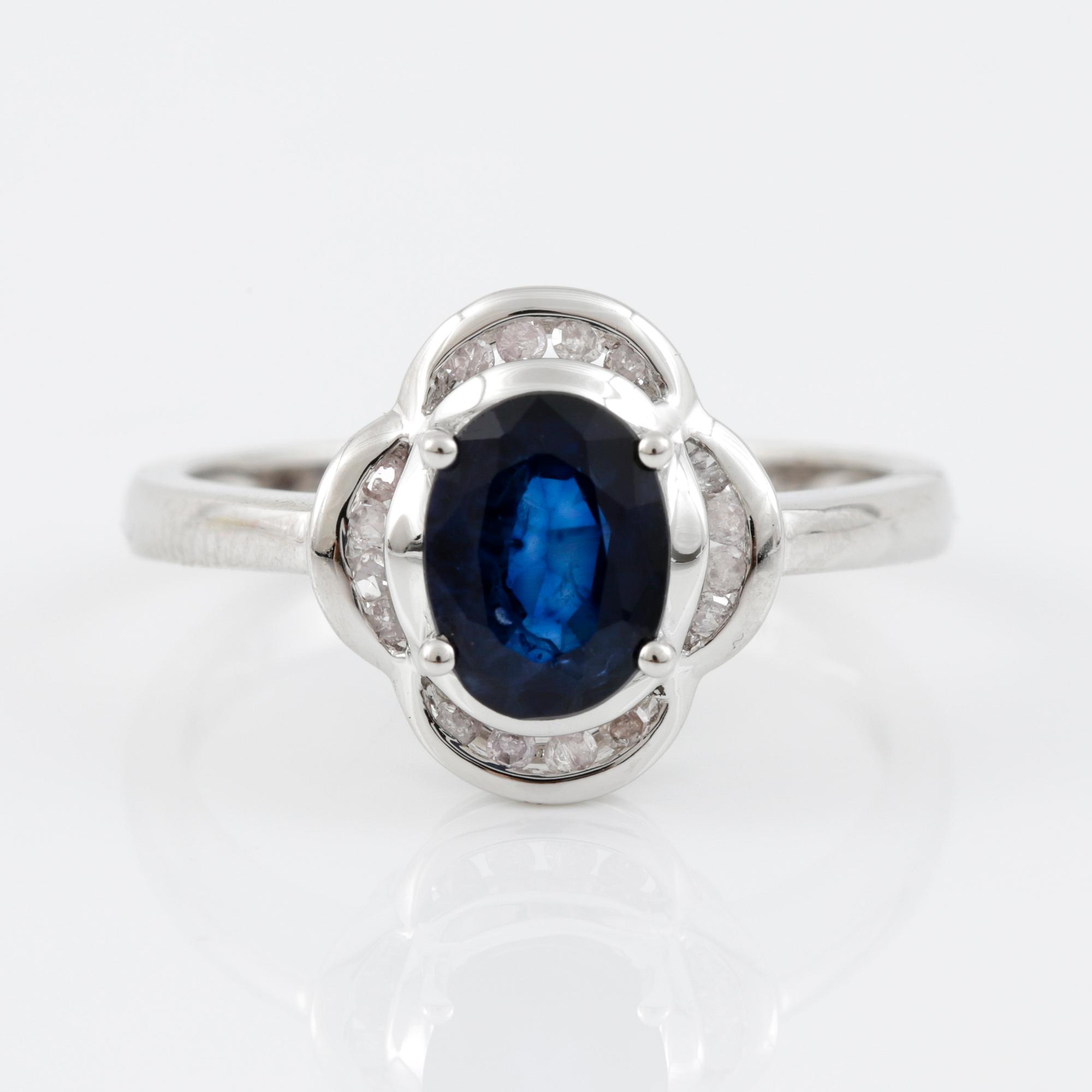 RING, 14K vitguld med ovalslipad safir tot ca 1,24 cts omgivs av 16 åttkantslipade diamanter. Vikt 3,47 g.