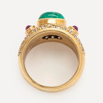 An ca 18K gold ring, with a cabochon-cut emerald and rubies, and brilliant-cut diamonds.