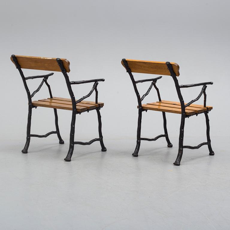 a pair of early 20th century garden cast iron chairs.