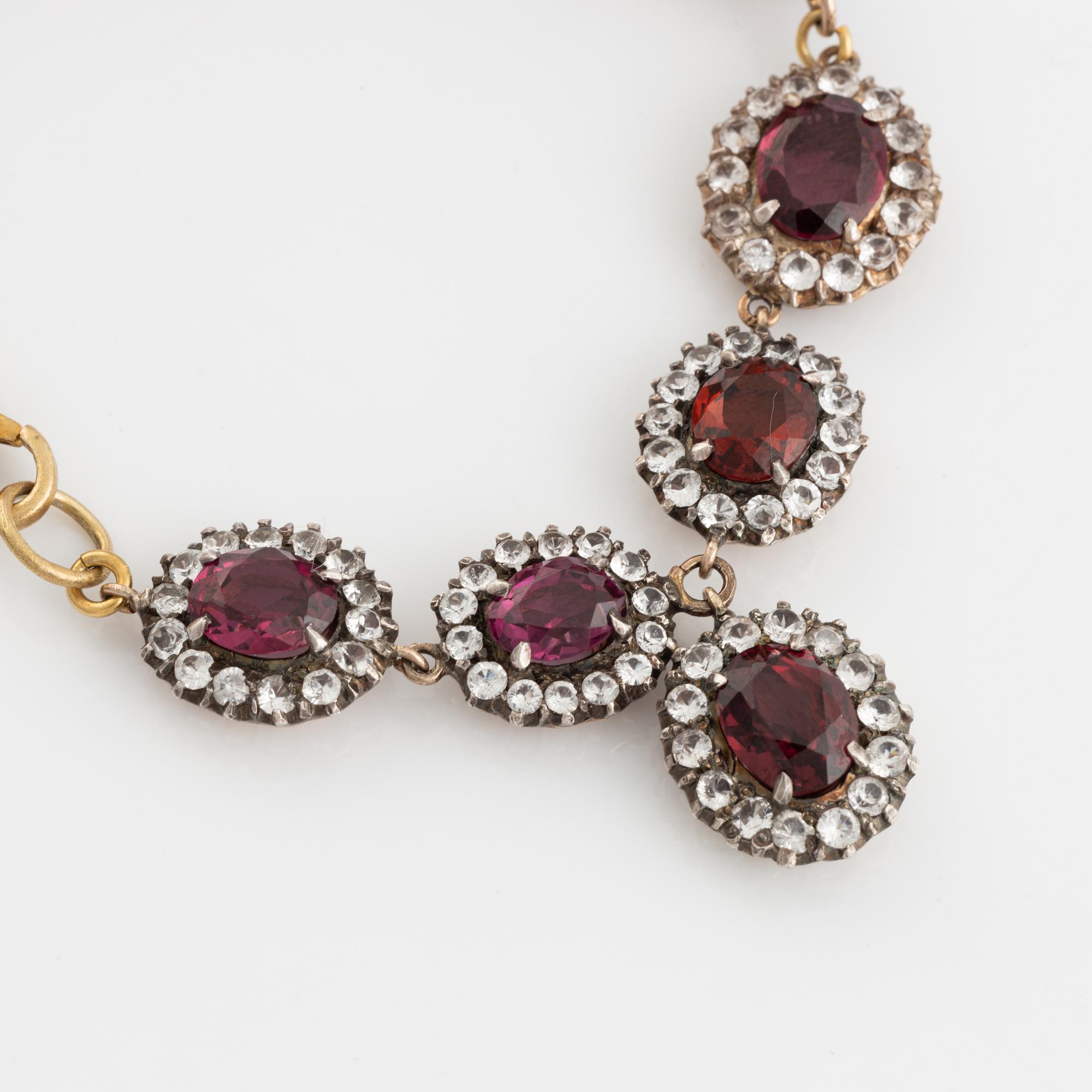Bracelet with garnets and white stones, two charms, one eye enamel with brilliant cut diamonds, possibly oriental pearl.