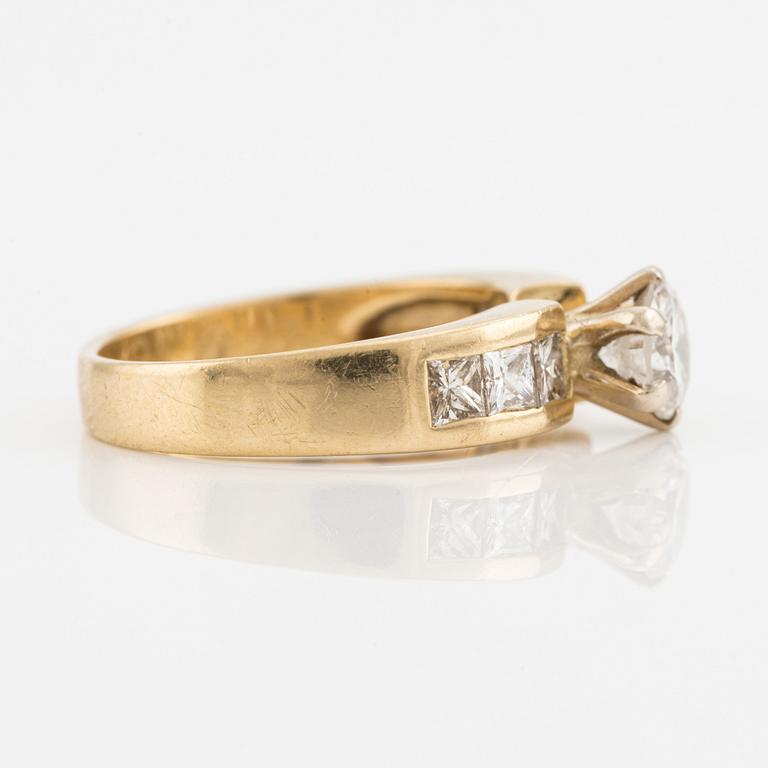 Ring, guld med briljantslipad diamant samt prinsesslipade på sidorna.