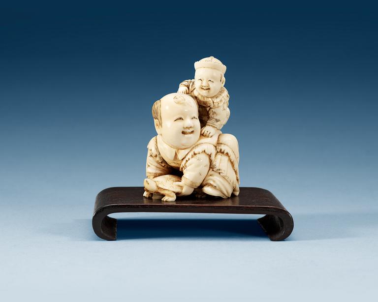 A carved ivory figure of two boys playing with at turtle, Qing dynasty.