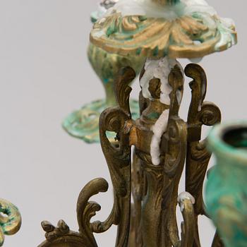 A pair of gilt-bronze Rococo Revival candelabra with porcelain decors, from the latter half of the 19th century.