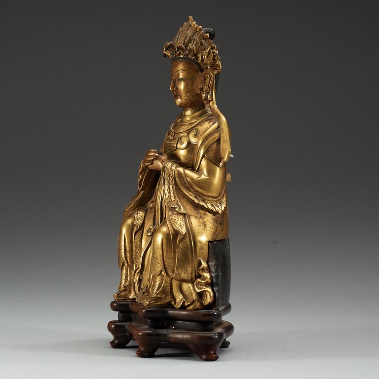 A gilt bronze figure of a sitting female deity, Qing dynasty, 18th Century.