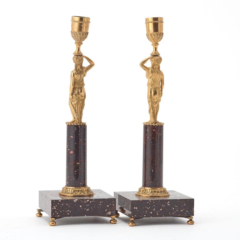 A pair of late gustavian early 19th century porphyry and ormolu candlesticks.