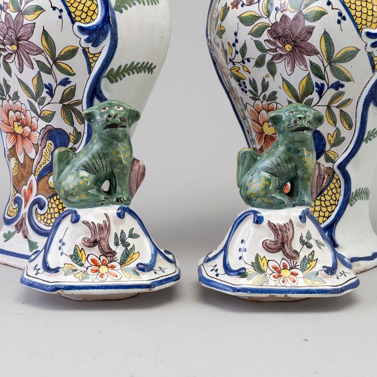 A pair of faience lidded urns, 18th/19th century.
