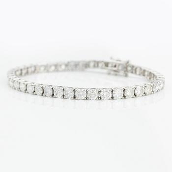 An 18K gold tennis bracelet with round brilliant-cut diamonds.