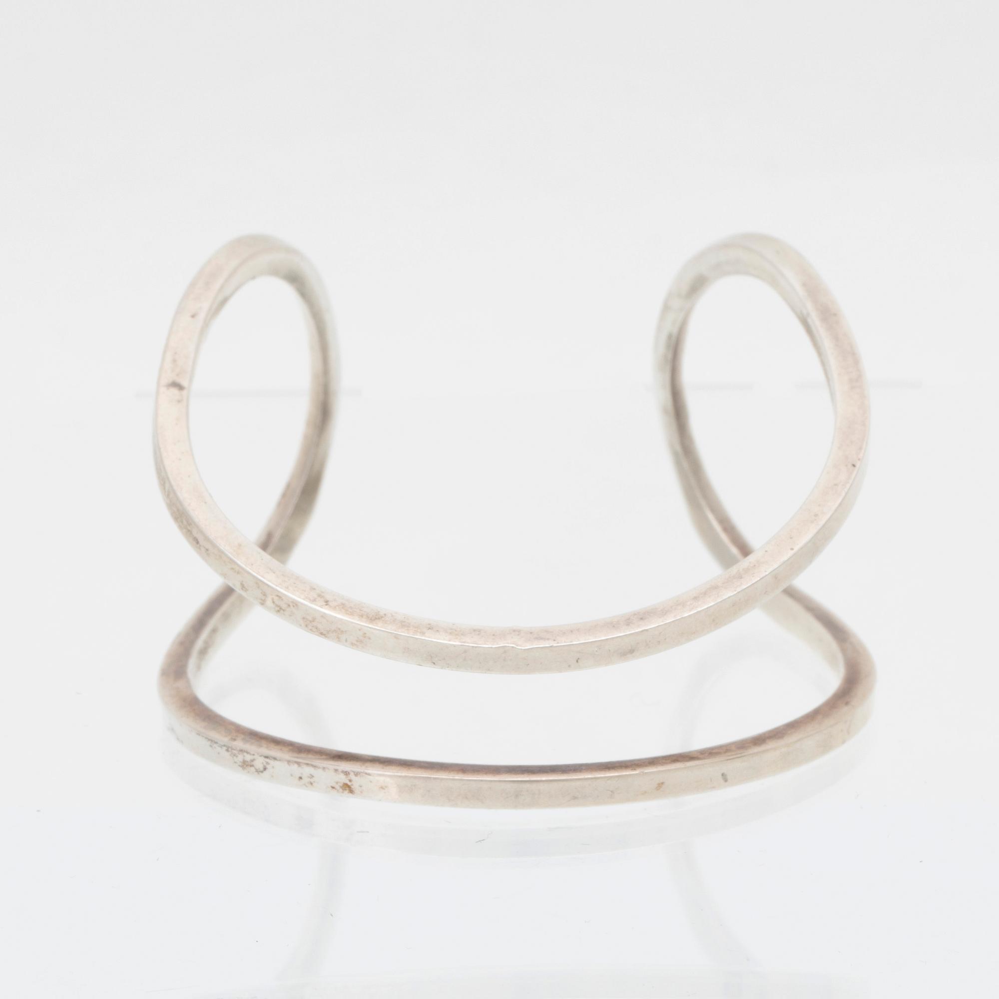 Efva Attling, stelt armband "Loop cuff" samt örhängen av silver.