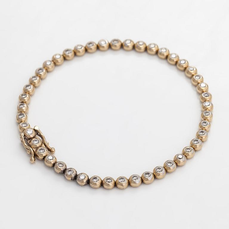 An 18K gold tennis bracelet, with diamonds totalling approximately 0.78 ct.