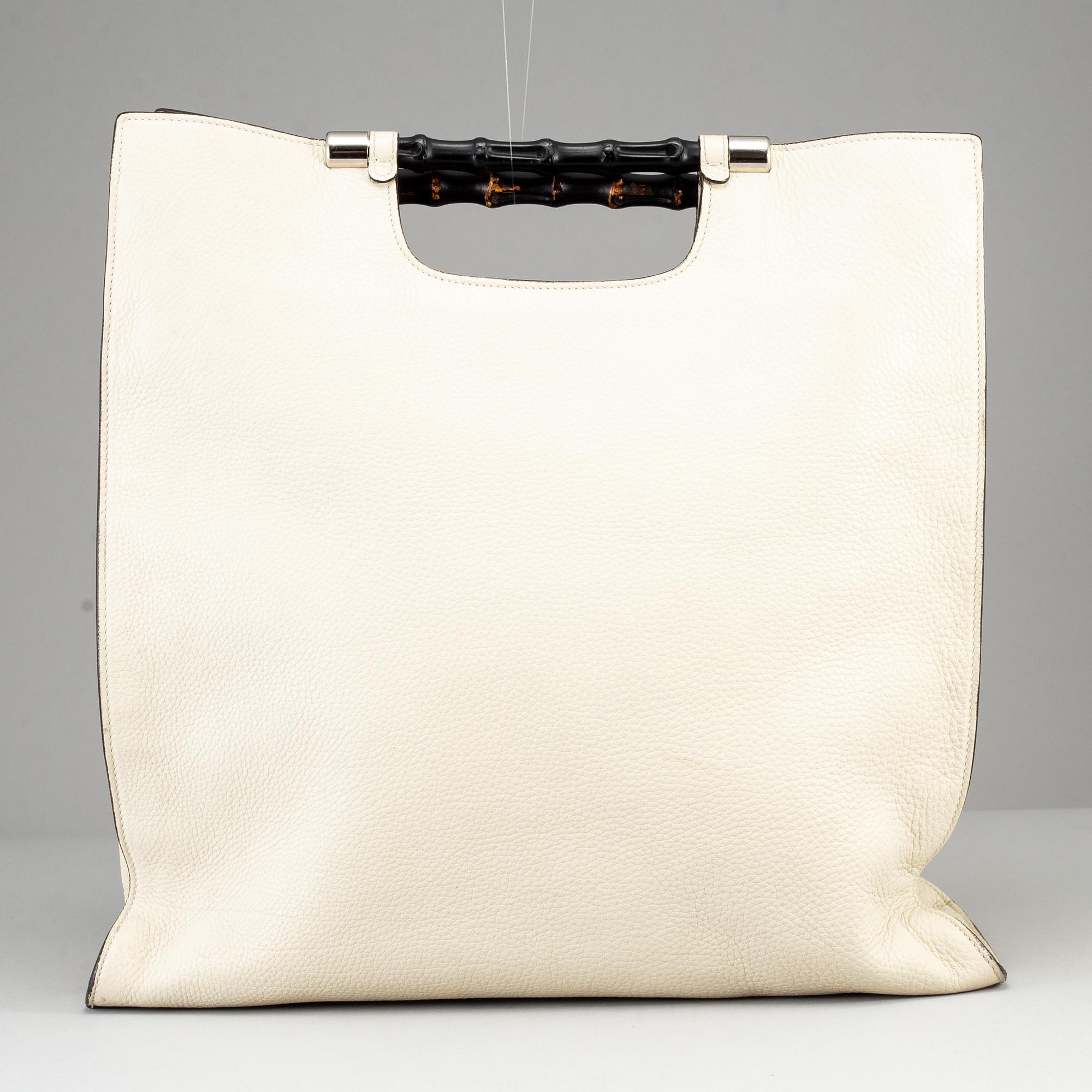 GUCCI, a white leather tote bag with bamboo handles.