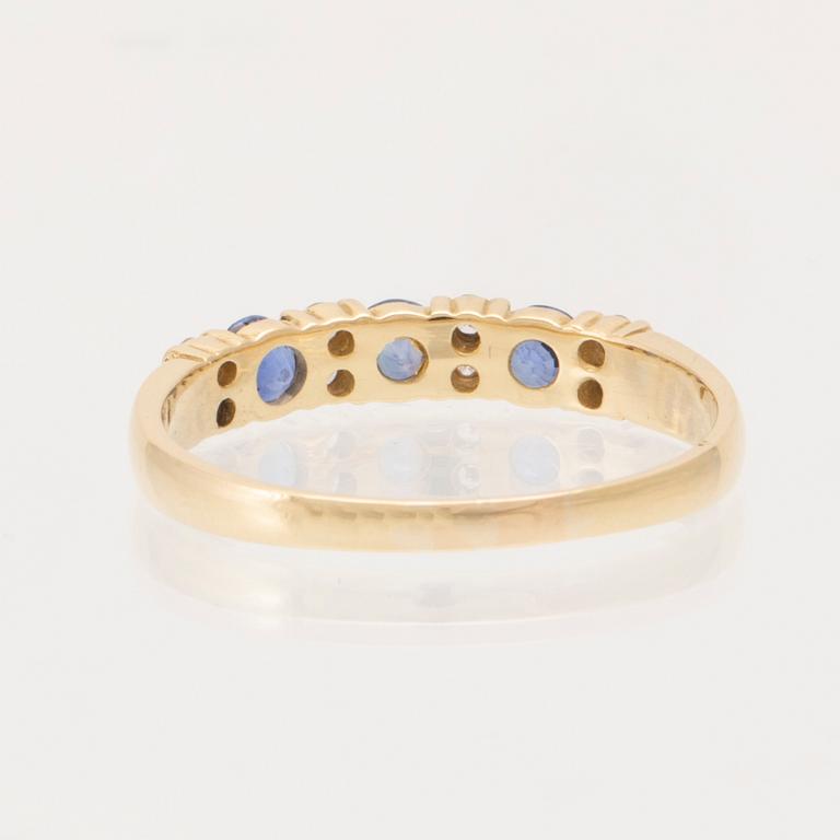 Ring 18K guld med runda briljantslipade diamanter och runda fasetterade blå stenar, London England.