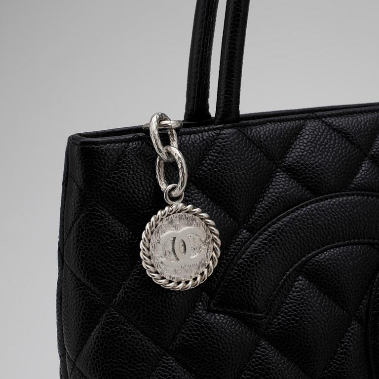 CHANEL, a black leather "Shopping" handbag.