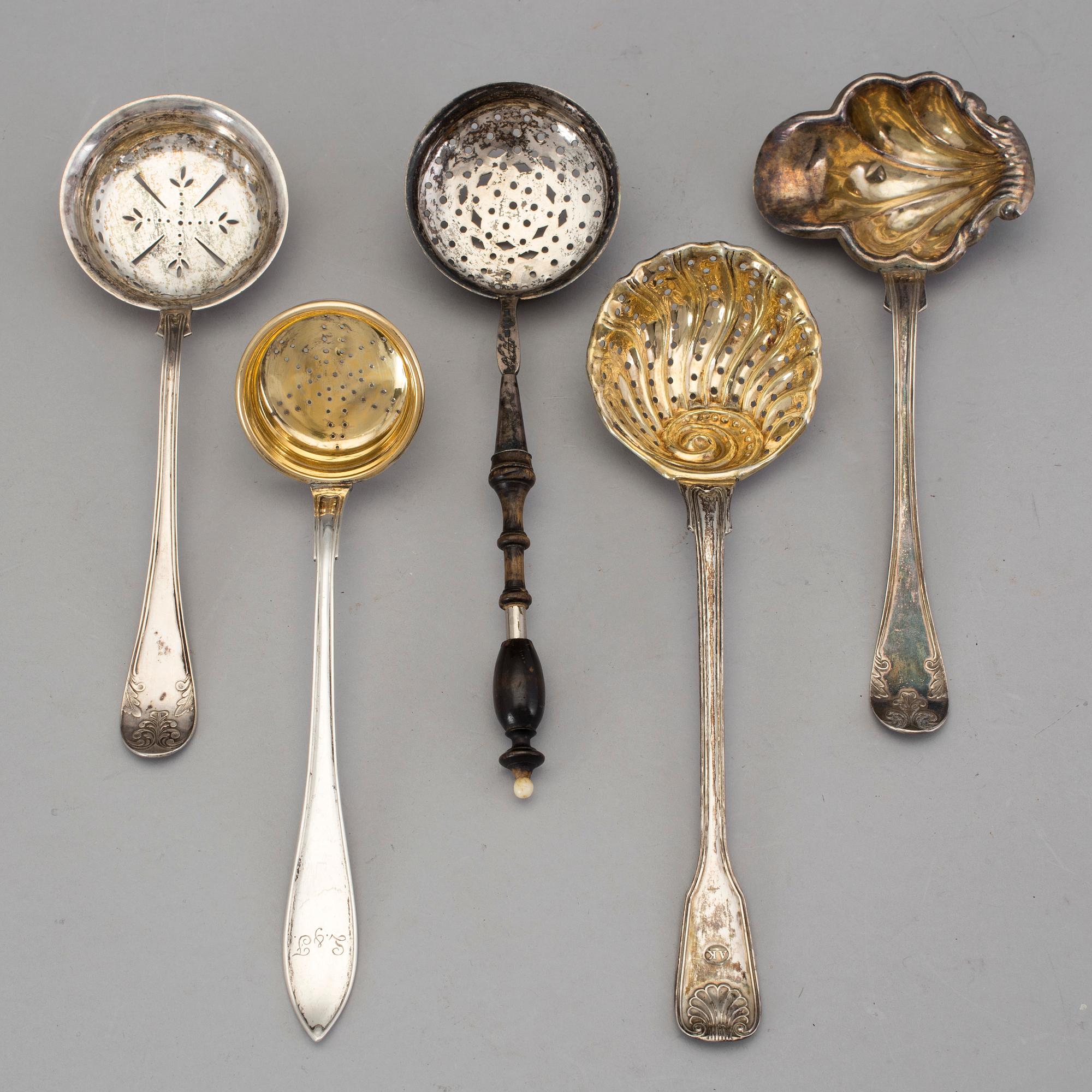 Four Swedish 19th-/20th century parcel-gilt caster-spoons and a sauce-spoon.
