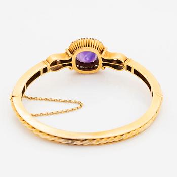 A 14K gold bangle set with a faceted amethyst and rose-and old-cut diamonds.