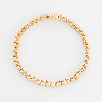 An 18K gold bracelet set with round brilliant-cut diamonds.