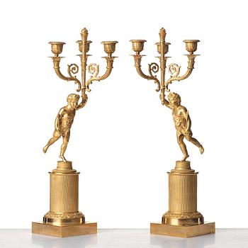 A pair of French Empire early 19th century three--light candelabra.