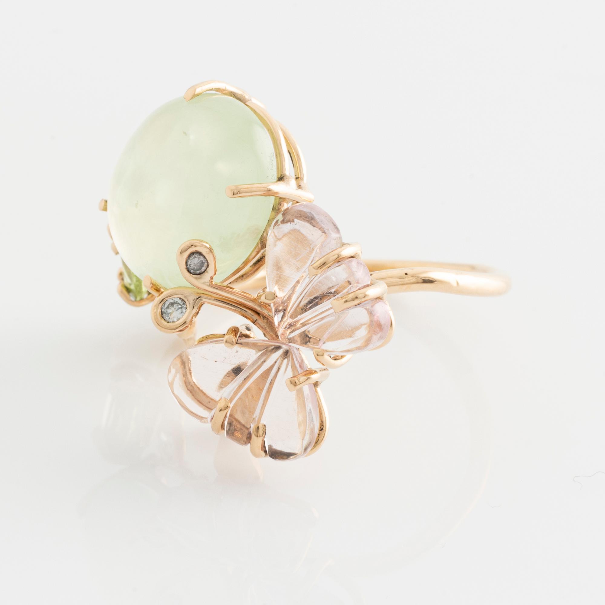 Ring with cabochon-cut prehnite, cut tourmaline in the shape of a butterfly, peridot, and brilliant-cut diamonds.