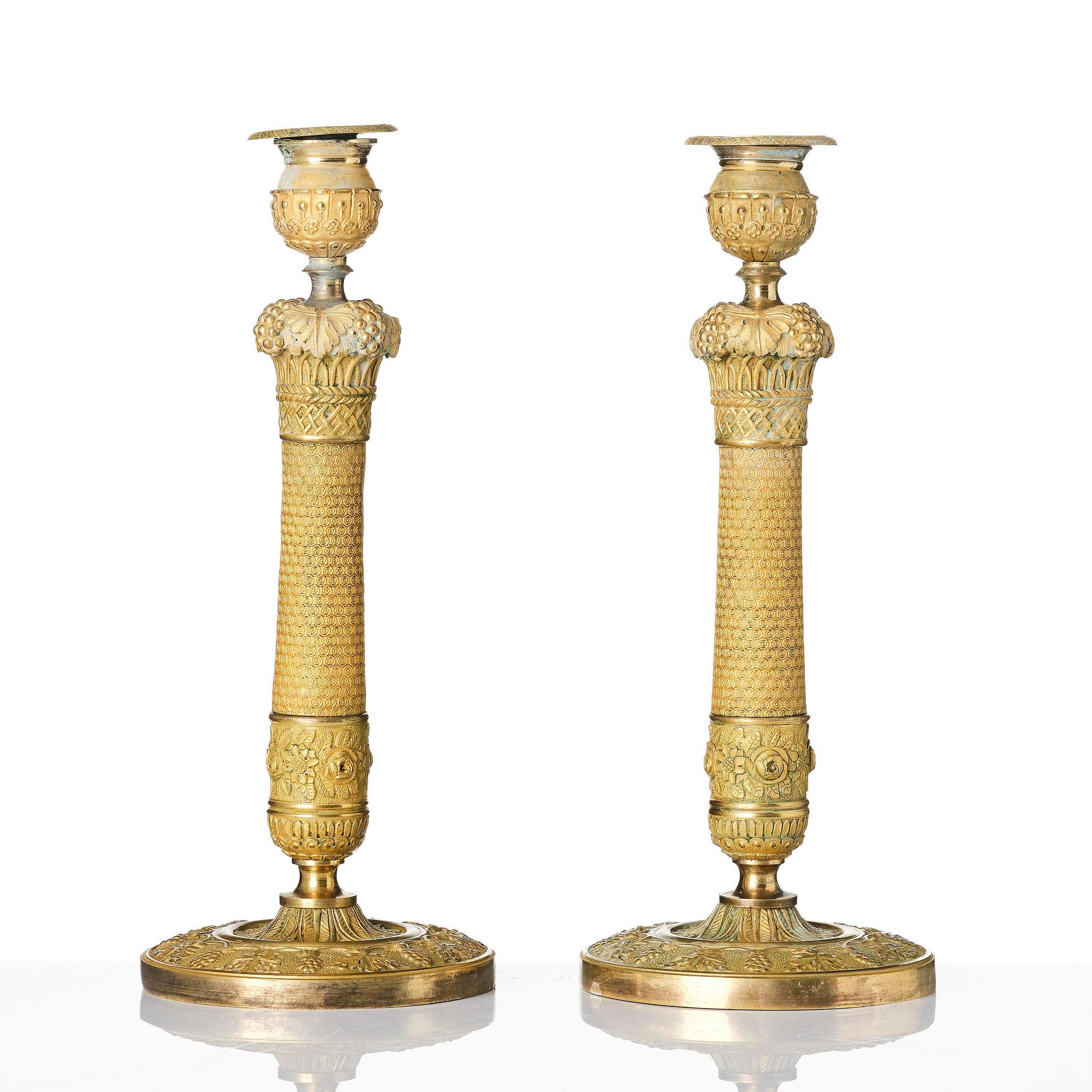 A pair of French Empire ormolu candlesticks, ca 1820's.